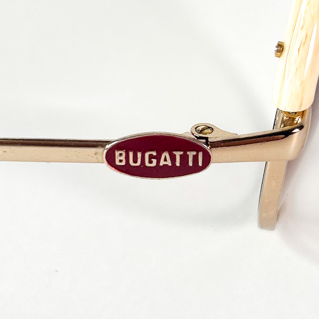Détail du logo Bugatti émaillé rouge sur la branche métallique dorée