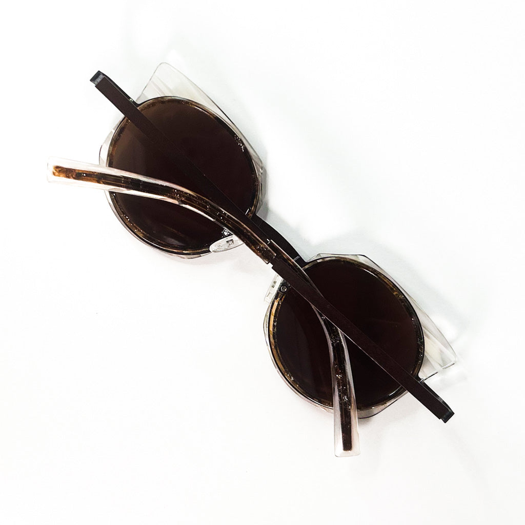 Vue de dessus des lunettes JF Rey JF2720 posées sur une surface blanche, branches croisées, verres ronds teintés bruns