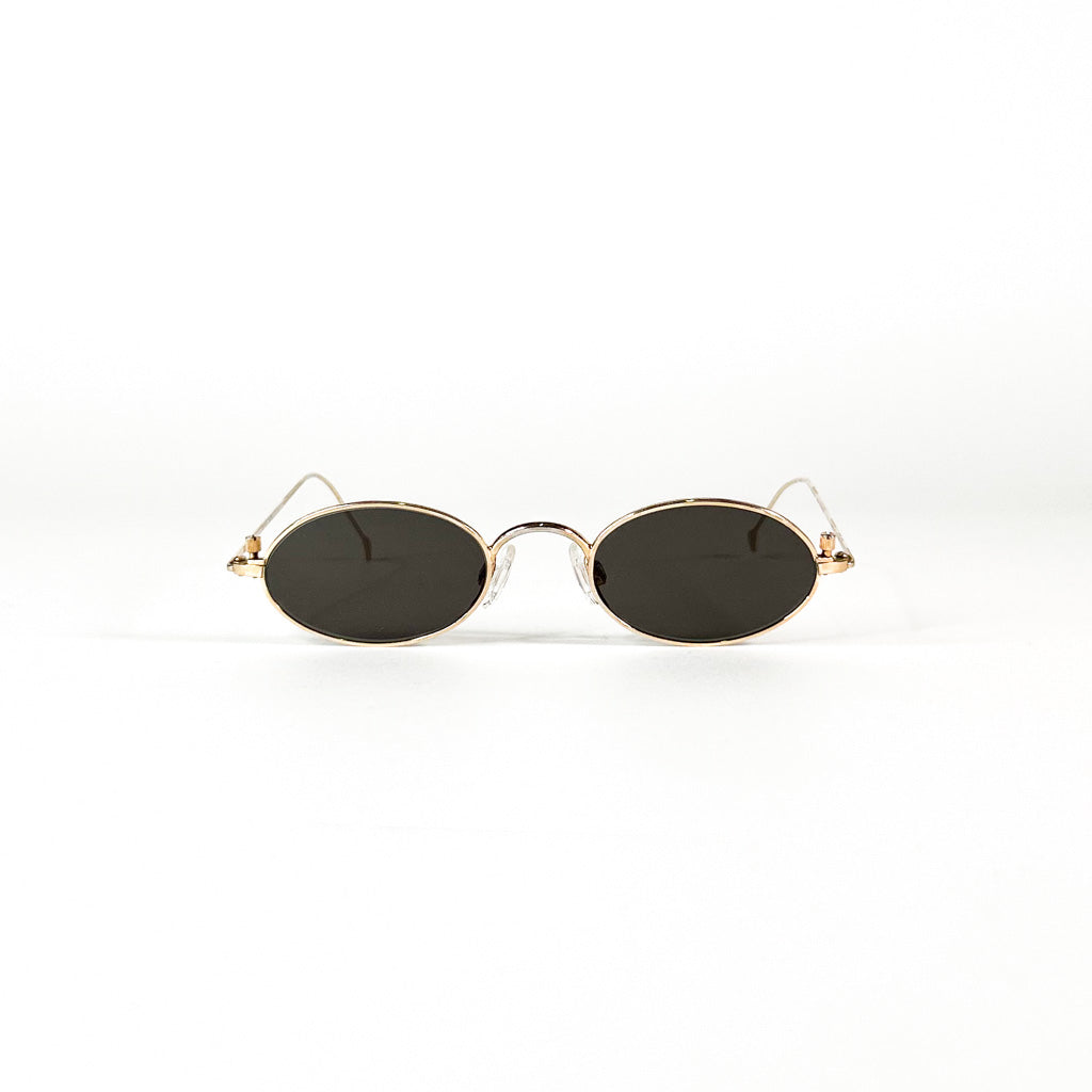  vue de face de la paire de lunettes Paco Rabanne posée, montrant les verres ovales noirs et les plaquettes de nez transparentes