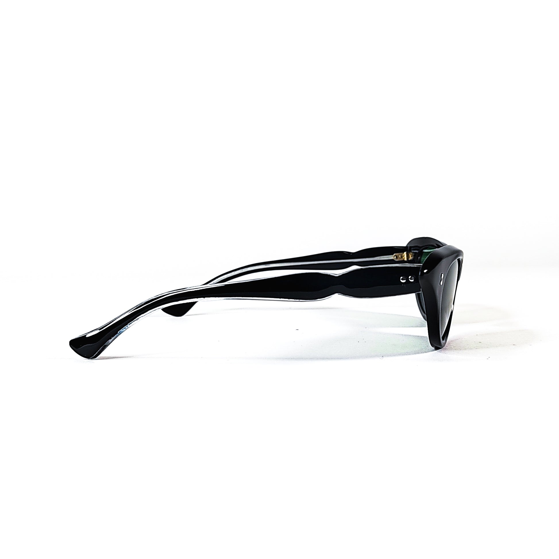 Vue latérale des lunettes vintage œil-de-chat noires aux branches courbées avec verres verts