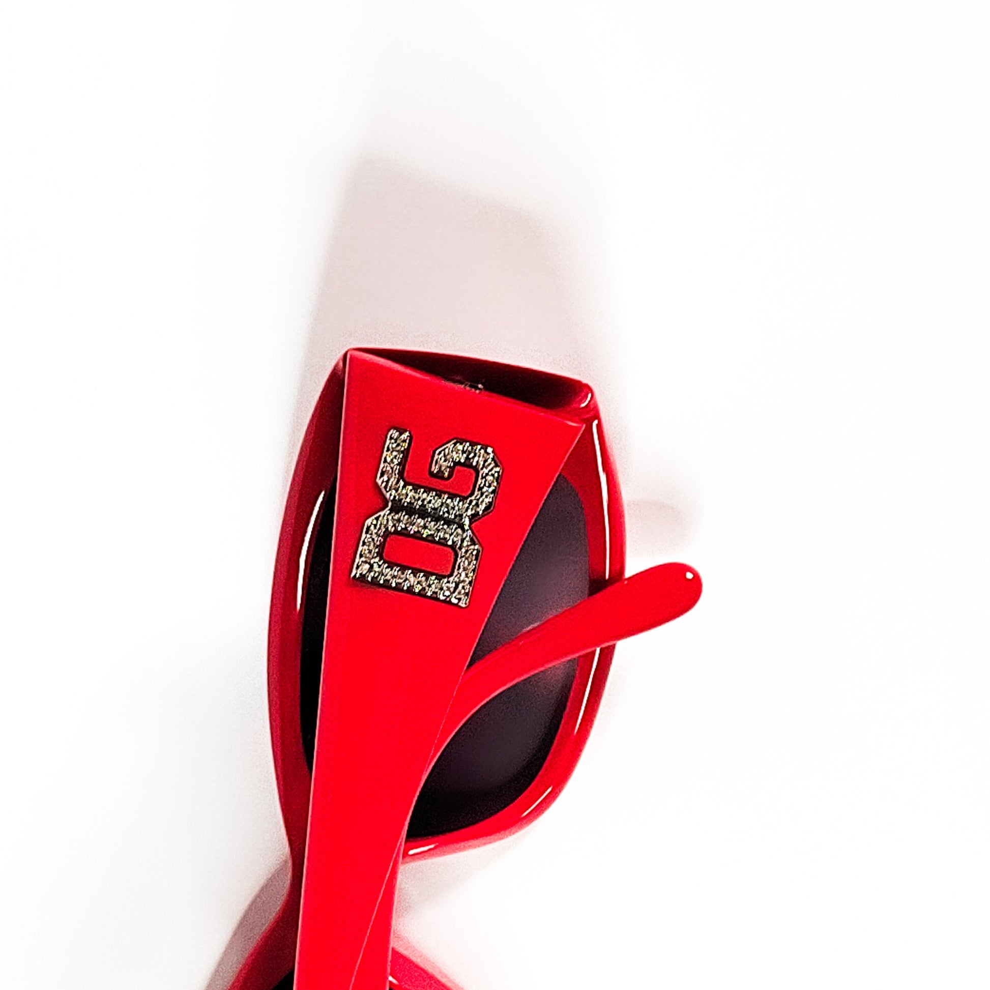 Gros plan logo DG cristal serti sur branche rouge Dolce & Gabbana DG 4008-B vintage.