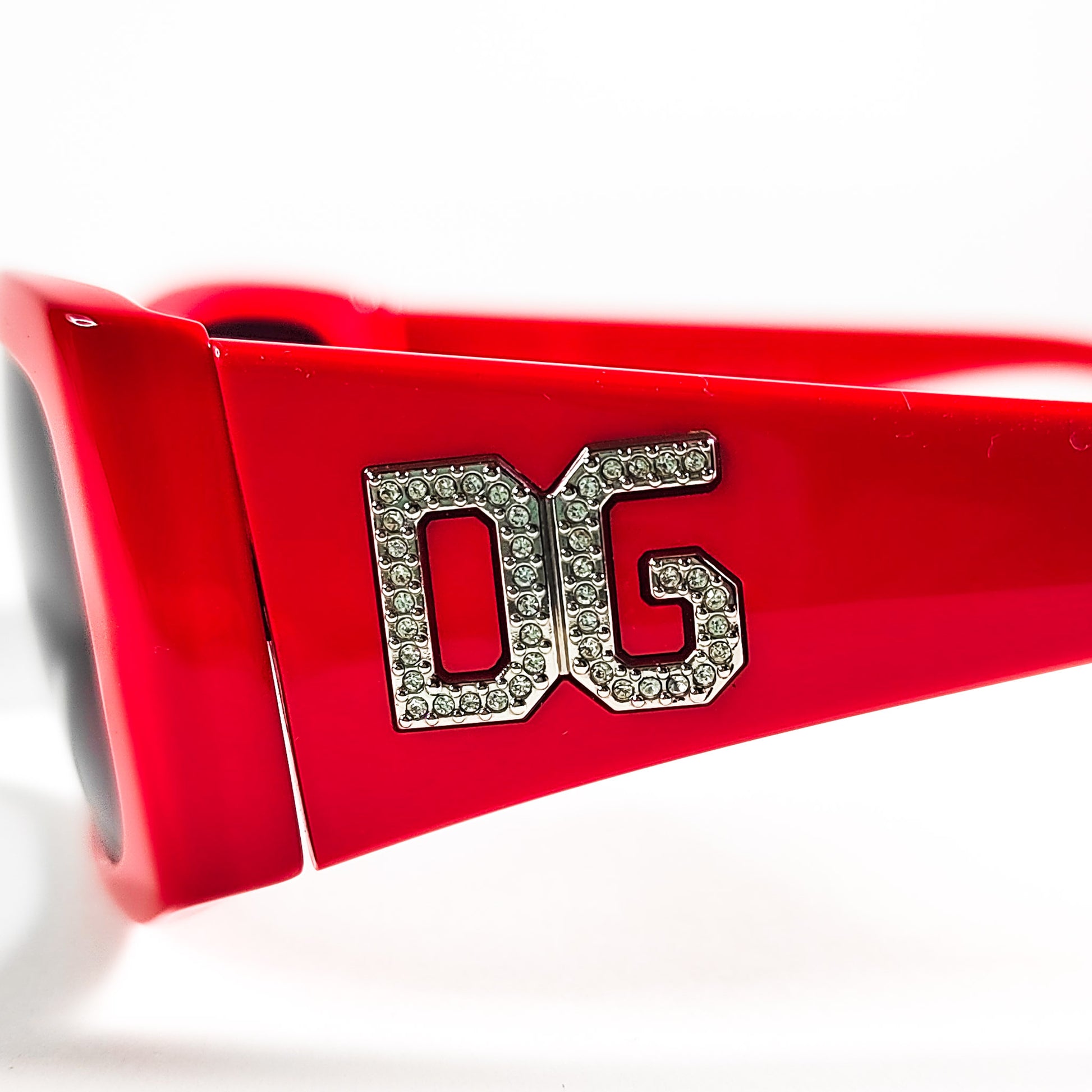 Détail macro du logo DG strass platine sur la branche rouge laquée Dolce & Gabbana 4008-B.